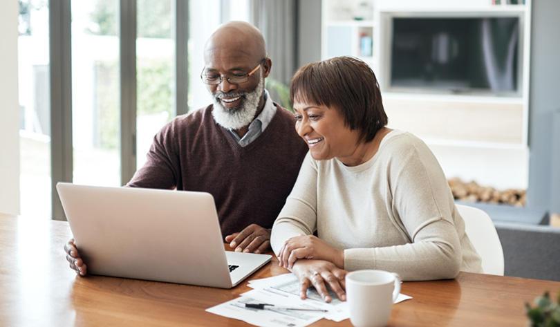 Older couple looking at a laptop and smiling for some reason