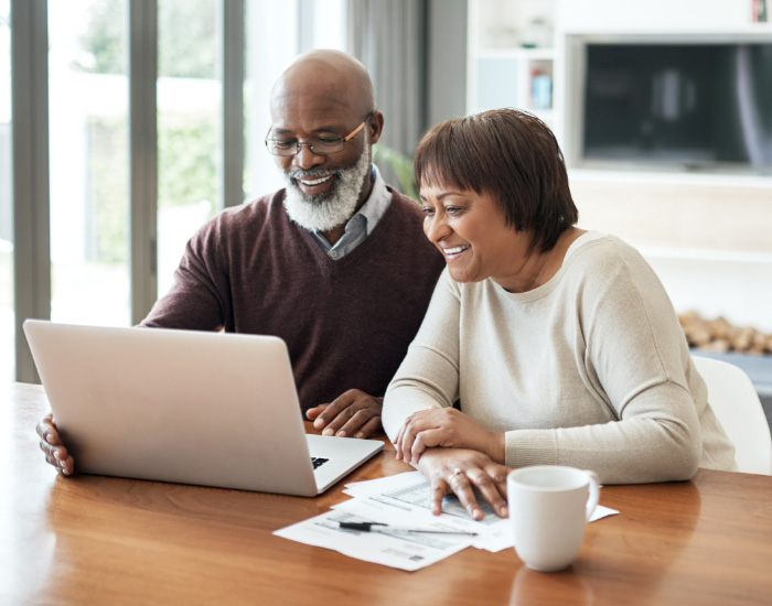 couple looking at laptop and smiling for some reason