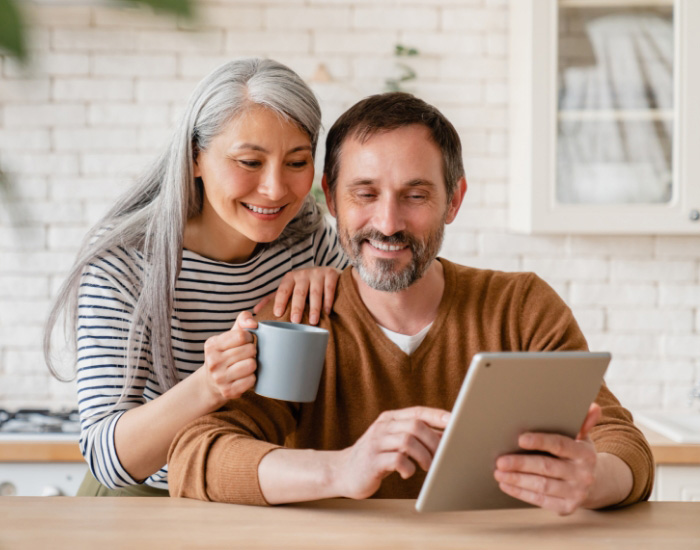 couple looking at laptop and smiling for some reason