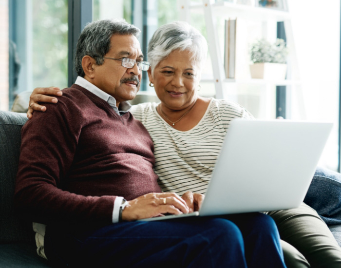 couple looking at laptop and smiling for some reason