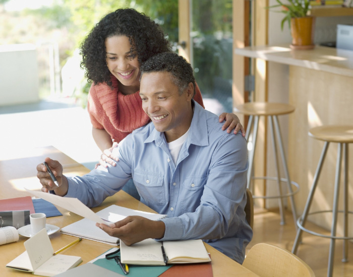 couple looking at laptop and smiling for some reason