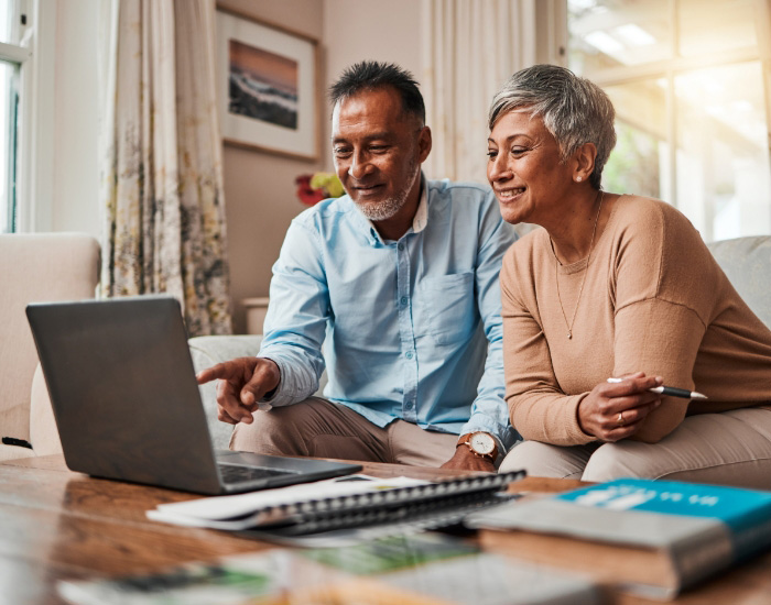 couple looking at laptop and smiling for some reason