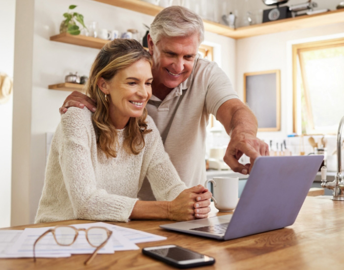 couple looking at laptop and smiling for some reason